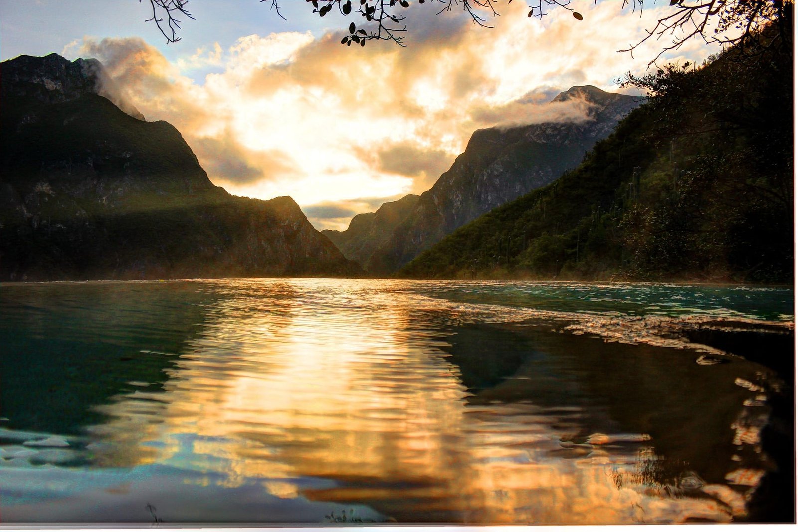 Un lago largo que refleja el cielo y sus nubes junto con montañas al lado del mismo en Hidalgo